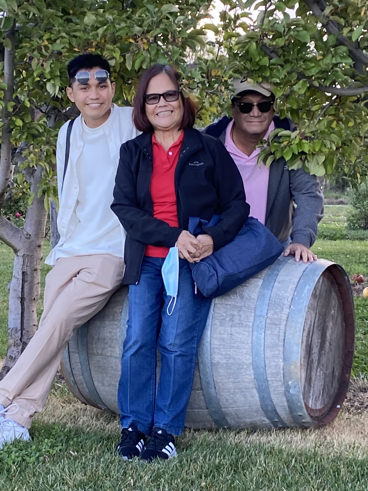 three people sitting on wine barrel
